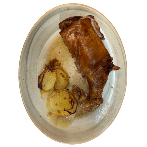 plato de cochinillo al horno con patatas panaderas
